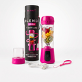 A pink portable blender bottle with its black cylindrical carrying case, a small clear travel cup, a USB charging cable, and a pink wrist strap, all arranged on a clean white background. The blender bottle is filled with fruit and is branded BLENDI.