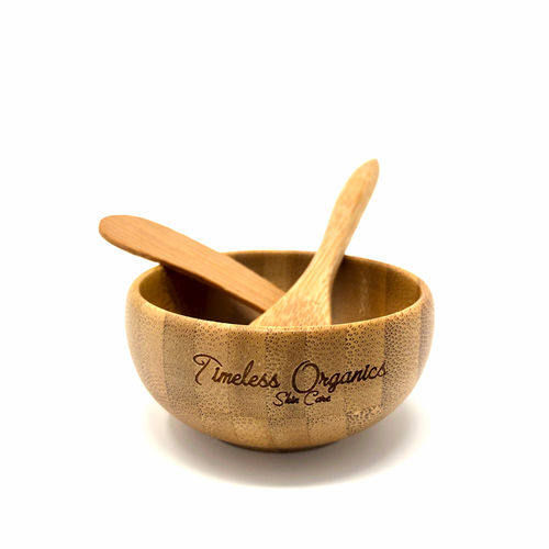 Bamboo bowl with two spoons on a white background, featuring 'Timeless Organics' branding.