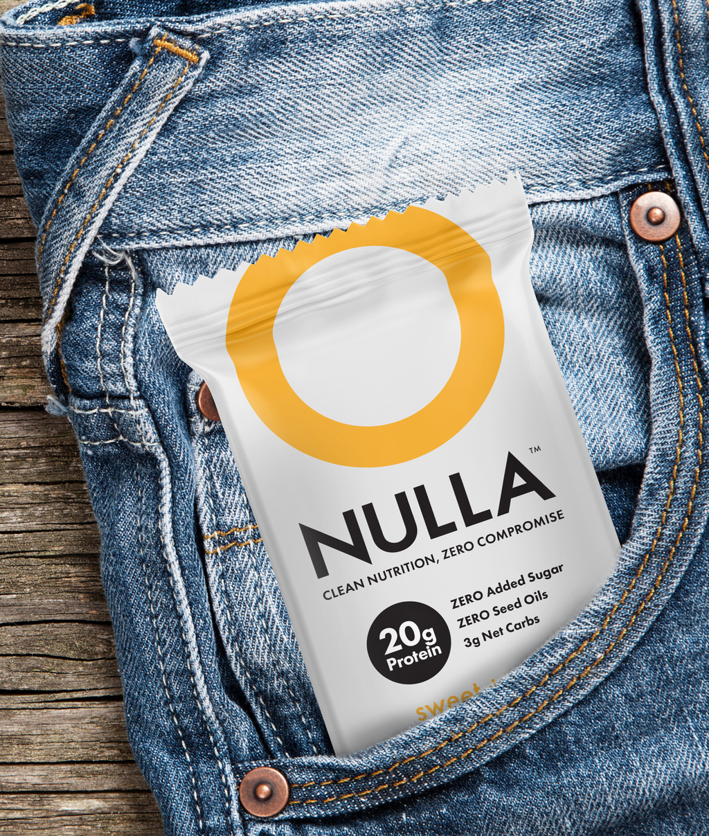 NULLA protein package in a blue denim pocket on a wooden surface