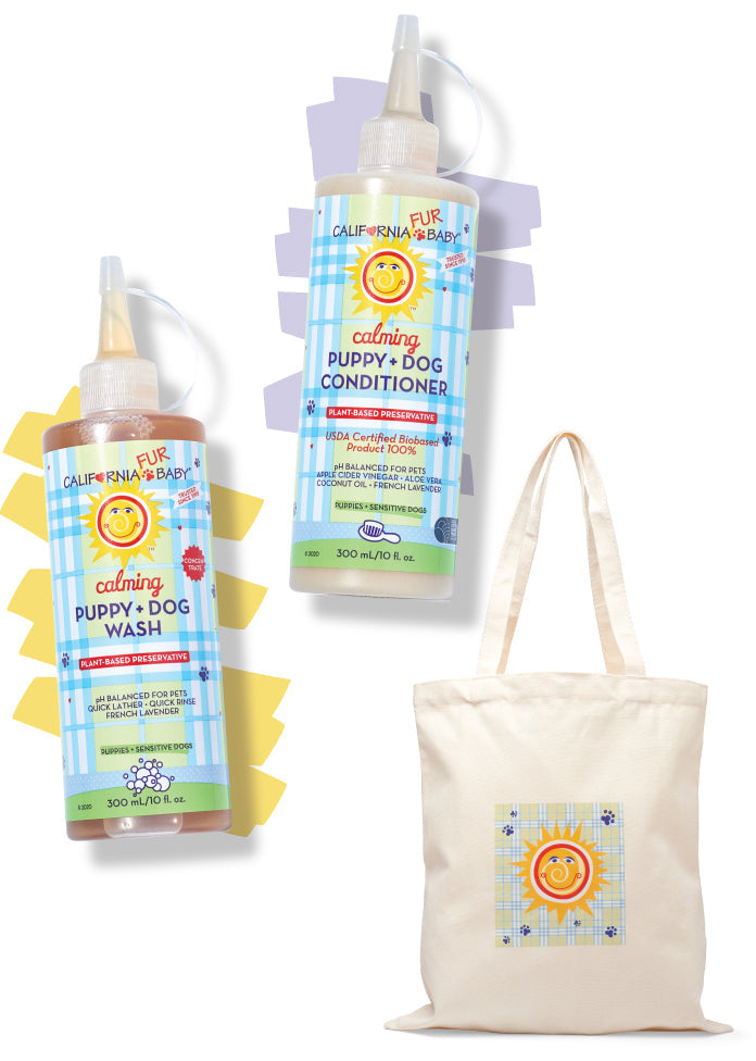 Two bottles of California Baby Calming™ Puppy + Dog Wash and Conditioner displayed with a matching branded canvas tote bag on a clean white background. Vegan pet grooming gift set for puppies and dogs.