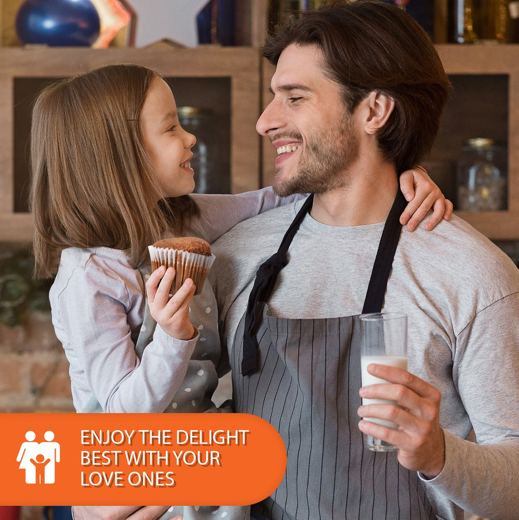 Father and young daughter sharing a warm smile in a cozy kitchen while enjoying a cappuccino muffin and a glass of milk, celebrating family time and homemade moments together.