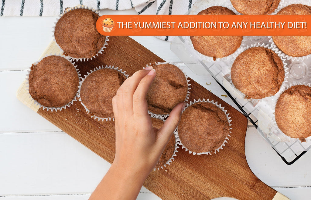 Hand reaching for a freshly baked cappuccino muffin on a wooden serving board surrounded by golden-brown muffins, with a banner reading "The Yummiest Addition to Any Healthy Diet!" Perfect for low-carb, sugar-free, keto-friendly breakfasts, coffee breaks, and wholesome bakery treats.