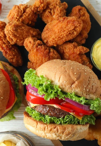 The Gathering Box featuring a gourmet hamburger with fresh lettuce, tomato, red onion, and a juicy beef patty, served alongside crispy pasture-raised chicken wings with a creamy dipping sauce—perfect for cookouts, parties, and family meals.