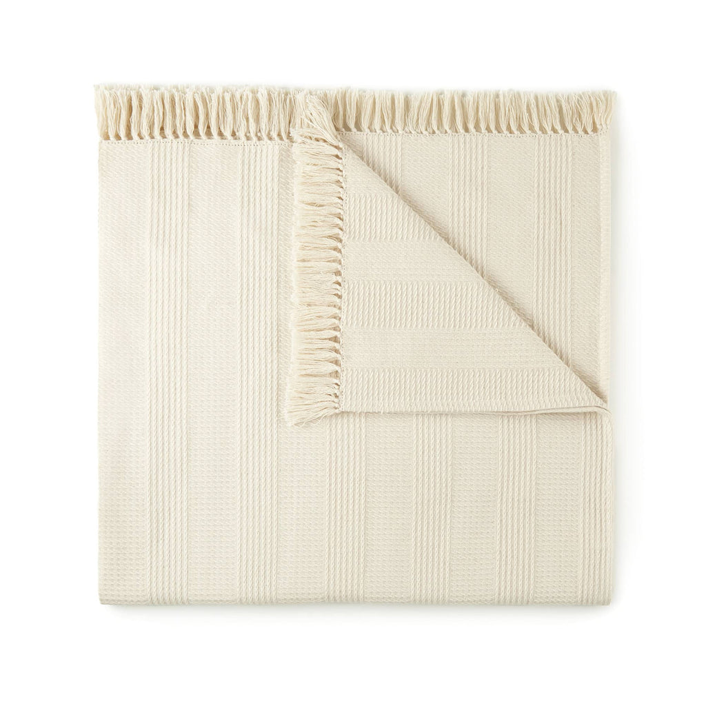 Beige textured blanket on a white background. Organic Cotton Throw with Tassels