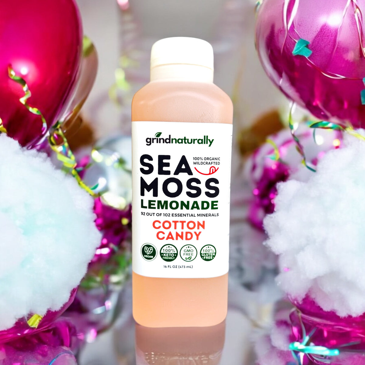 Bottle of Sea Moss Lemonade with cotton candy flavor against a festive background with balloons and confetti. #1 Flavored Sea Moss Lemonade (16oz)