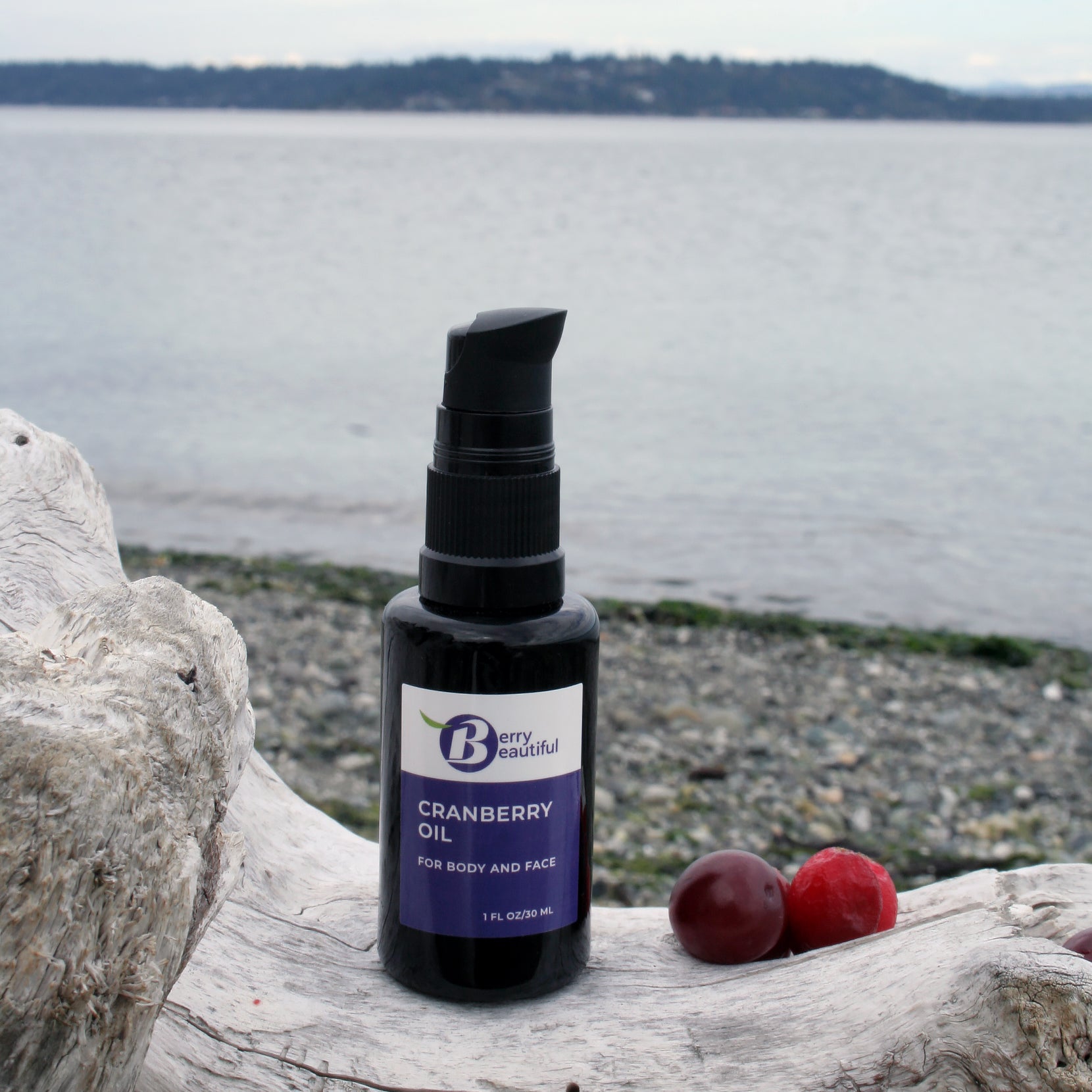 Bella Naturals Cranberry Oil bottle on a rock by a body of water