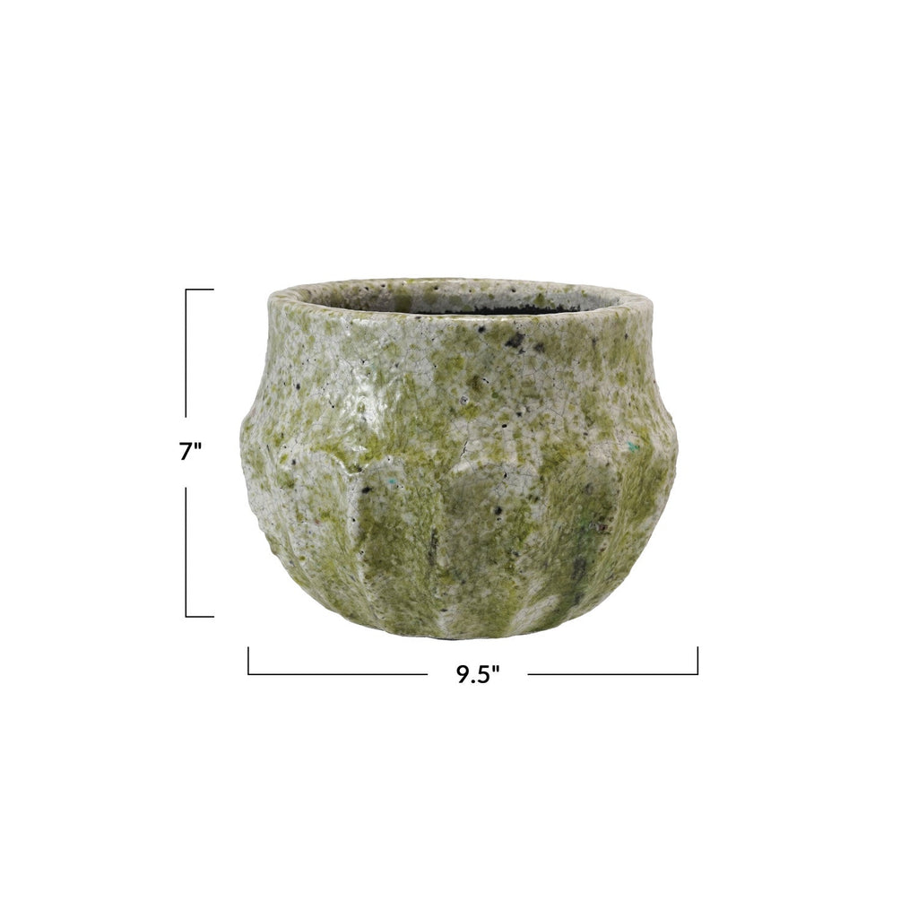 A small round stone planter pot with a textured, mossy green and gray surface, shown with dimension lines indicating a height of 7 inches and a width of 9.5 inches on a white background.