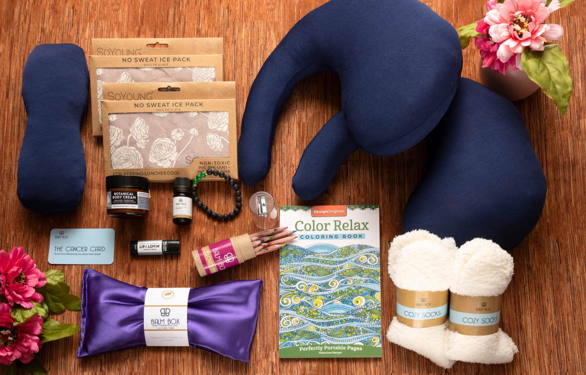 The Best Mastectomy Care Package featuring a navy blue travel neck pillow, sleep mask, cooling neck wrap, cozy socks, lip balm, coloring book, aromatherapy and self-care essentials, thoughtfully curated cancer recovery, mastectomy recovery, breast cancer survivor, post-surgery comfort and wellness gift box from Tree of Life Grocers.