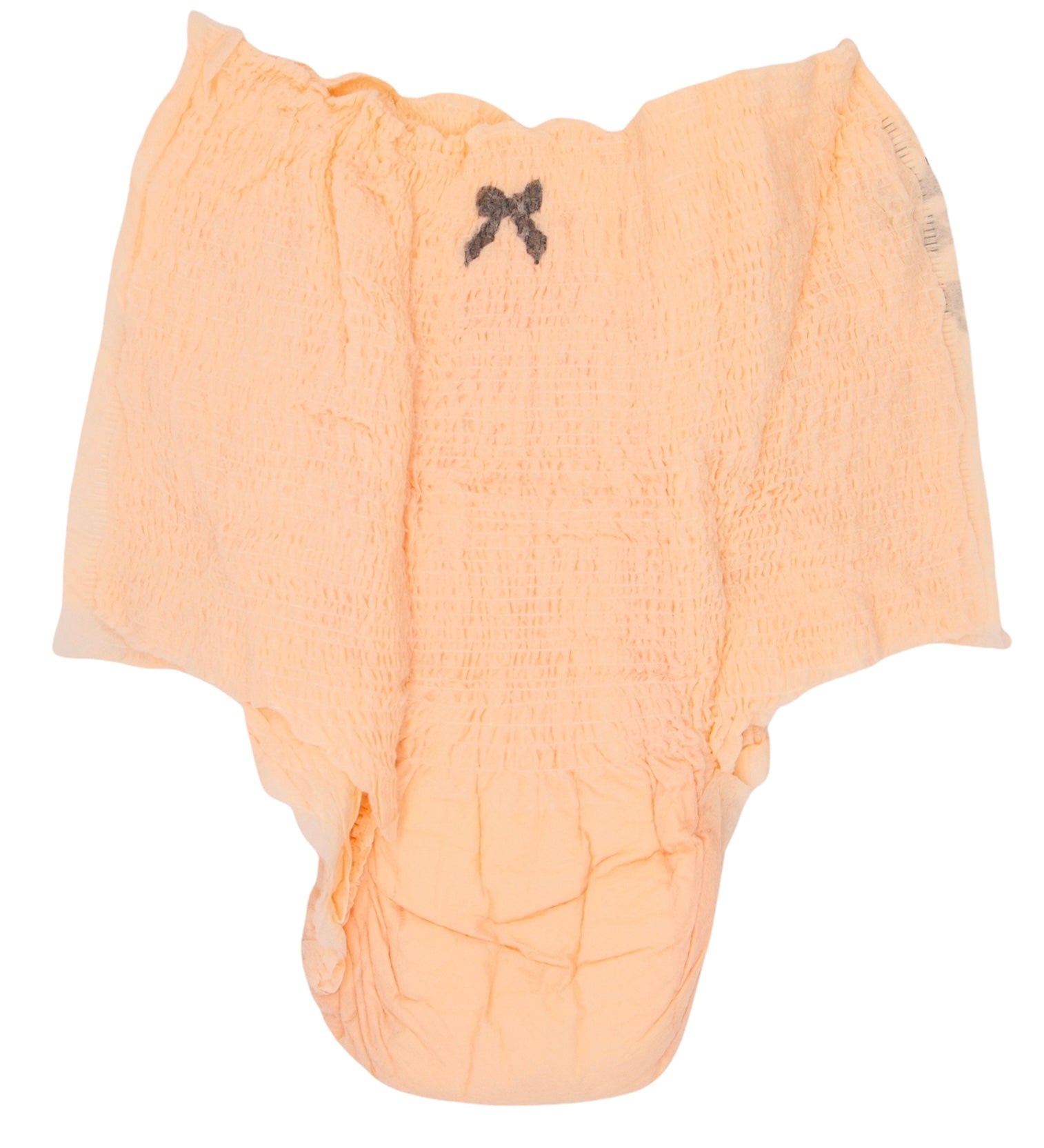 Light peach disposable baby diaper with a soft quilted design, stretch waistband, absorbent core, and a small black bow detail, isolated on a white background.