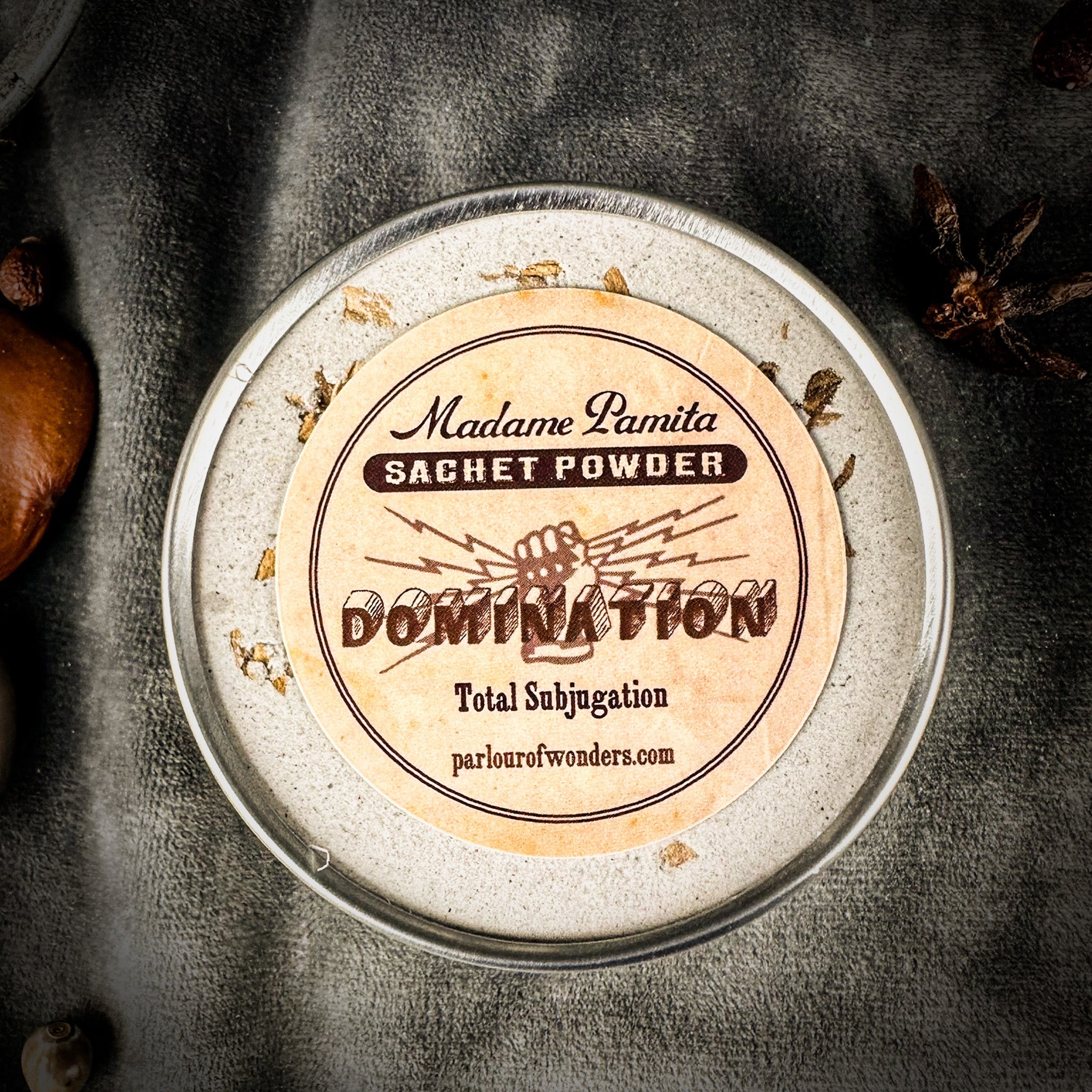 Sachet powder container with 'Madame Pamita' label on a dark background. Domination Sachet Powder by Madame Pamita