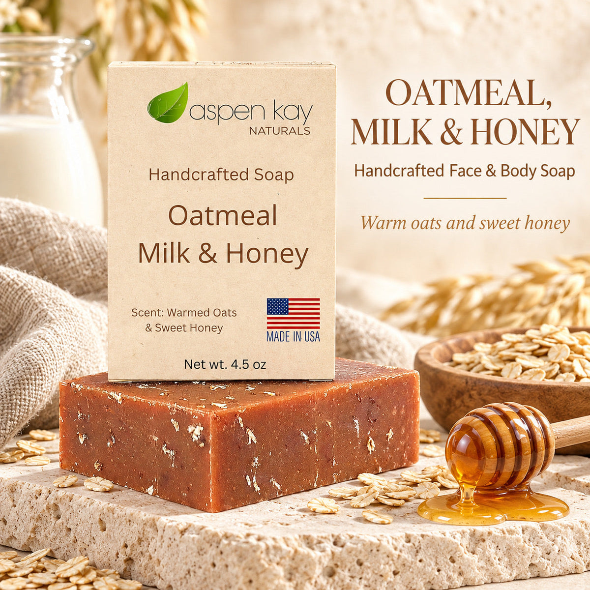 A handcrafted oatmeal milk and honey soap bar displayed on a stone surface with an Aspen Kay Naturals box behind it, alongside oats, honey, a honey dipper, and a glass of milk in a rustic styled setting.