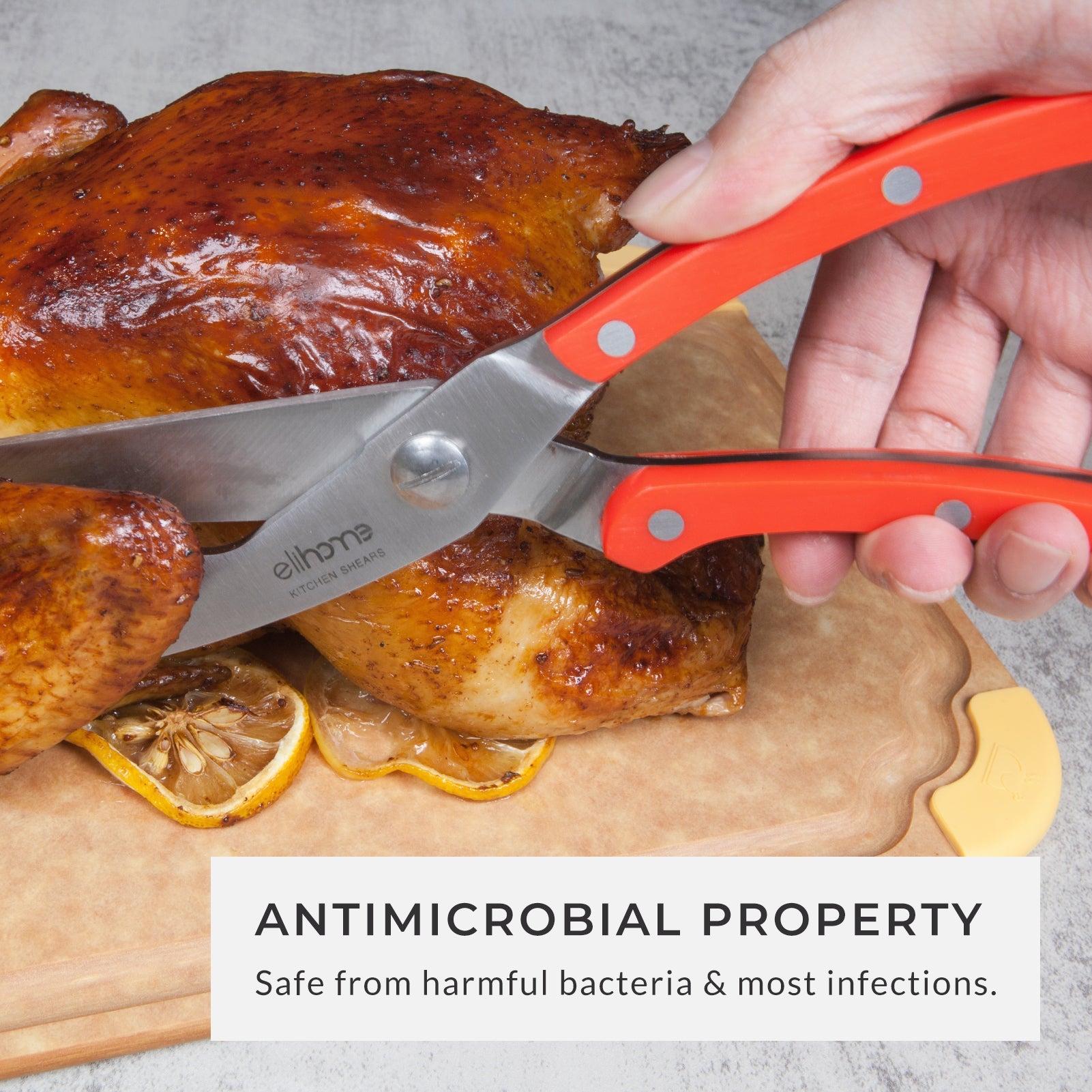 Person using premium red-handled kitchen shears to carve a roasted chicken on a durable antimicrobial cutting board, highlighting safe food preparation, hygienic kitchen use, and easy carving for home cooks.