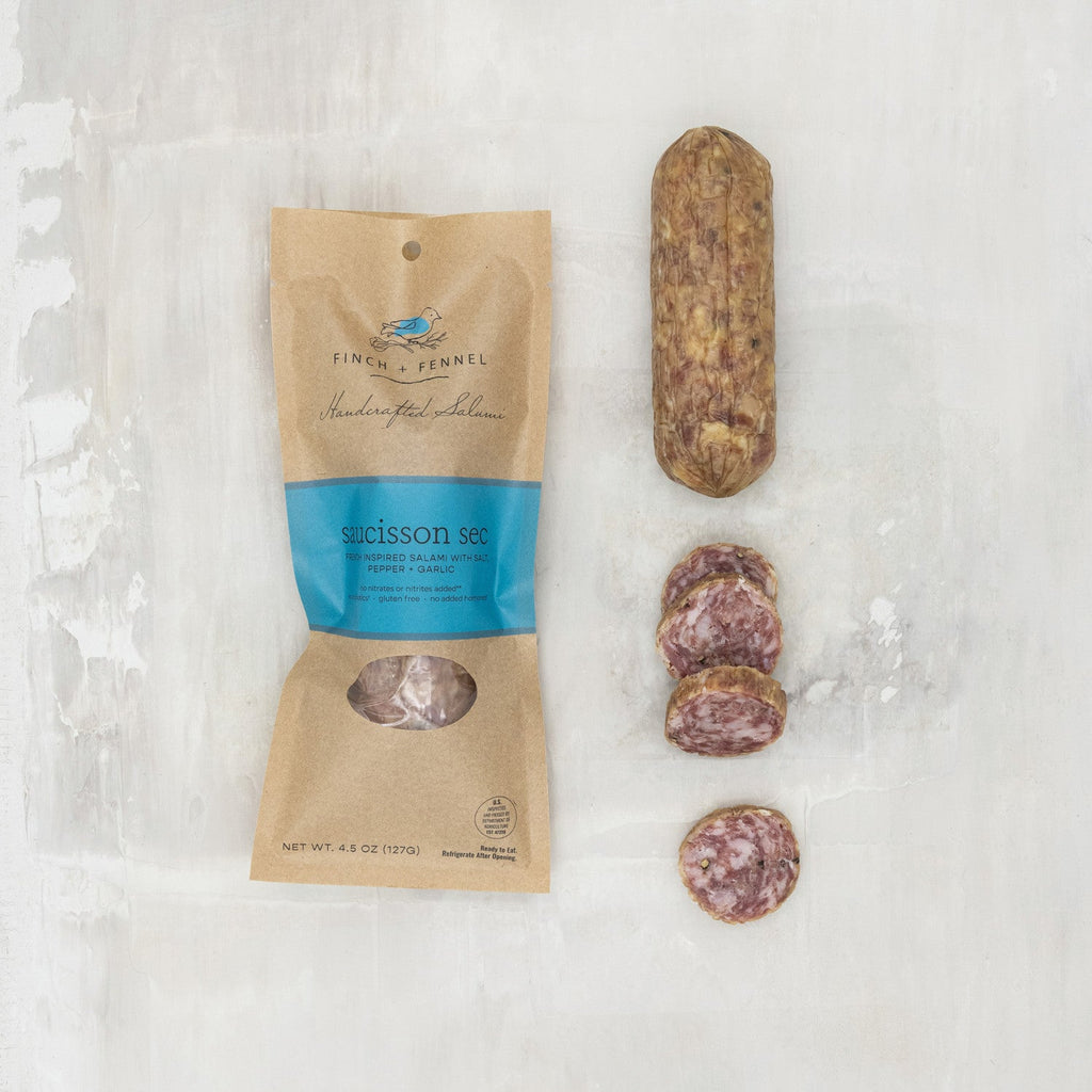 Finch & Fennel salami package with a sliced salami on a textured white background French Saucisson Sec Salumi | Finch + Fennel