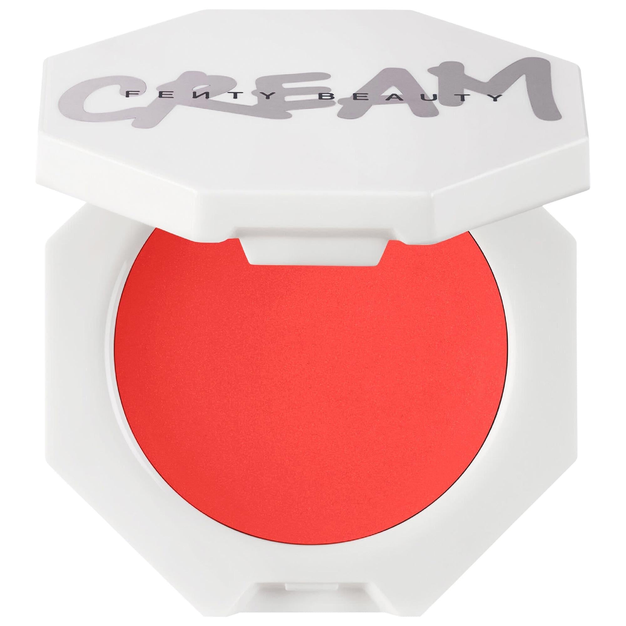 Fenty Beauty Cheeks Out Lightweight Cream Blush in an open white hexagonal compact, featuring a vibrant coral-red cream blush with a smooth matte finish.