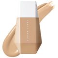 Fenty Beauty Eaze Drop Blurring Skin Tint foundation bottle with a beige foundation swatch on a white background.
