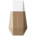 Fenty Beauty liquid foundation bottle with a faceted geometric design, featuring a warm medium tan shade on the lower half and a clean white cap on top, shown against a solid white background. Fenty Beauty Eaze Drop: Lightweight, Buildable Skin Tint Foundation for Natural, Blurred Finish | Vegan & Cruelty-Free