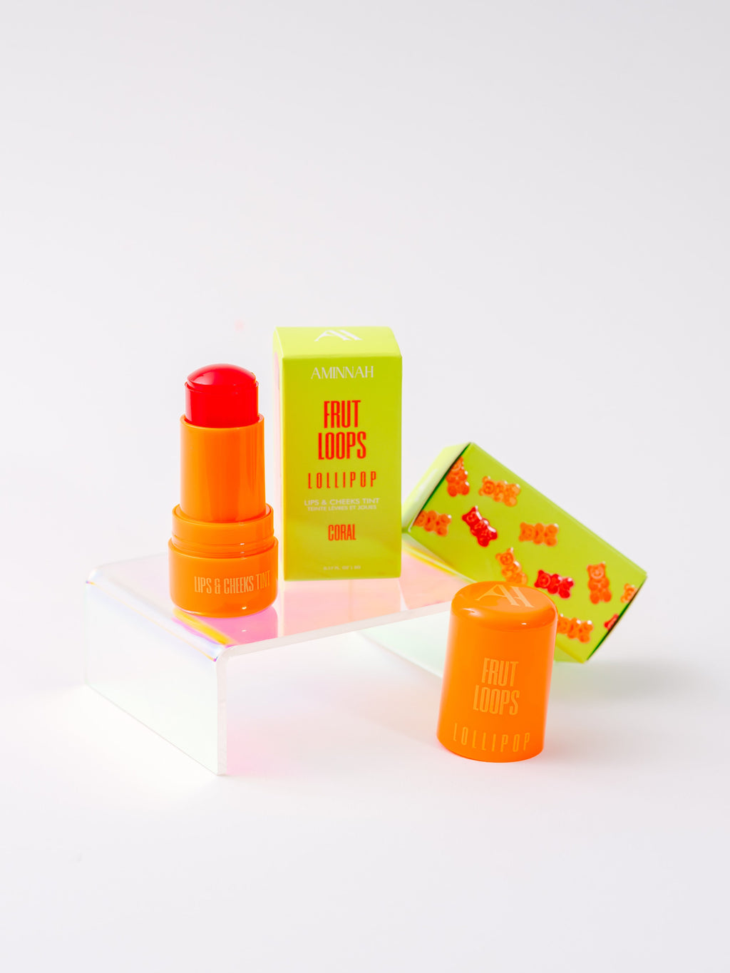 Fruit Loops LOLLIPOP Lips & Cheeks Tint in Coral by Aminnah displayed with vibrant packaging and open tint stick, clean beauty makeup made with natural ingredients, cruelty free, vegan, female owned brand, nourishing multi-use lip and cheek color for a fresh, radiant glow.