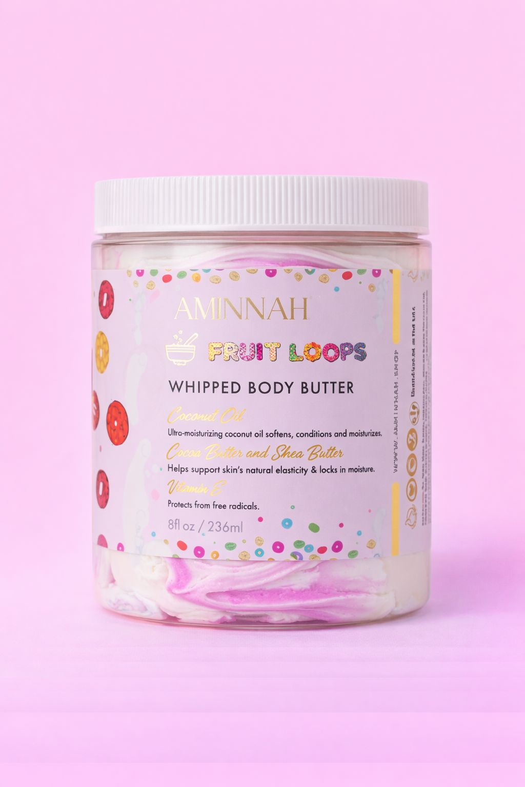 AMINNAH Frut Loops Whipped Body Butter in an 8 oz jar with colorful whipped body butter on a soft pink background. Clean beauty, cruelty-free, vegan body butter made with natural ingredients including shea butter, coconut oil, cocoa butter, and sweet almond oil to deeply moisturize and nourish skin. Female-owned brand available at Tree of Life Grocers.