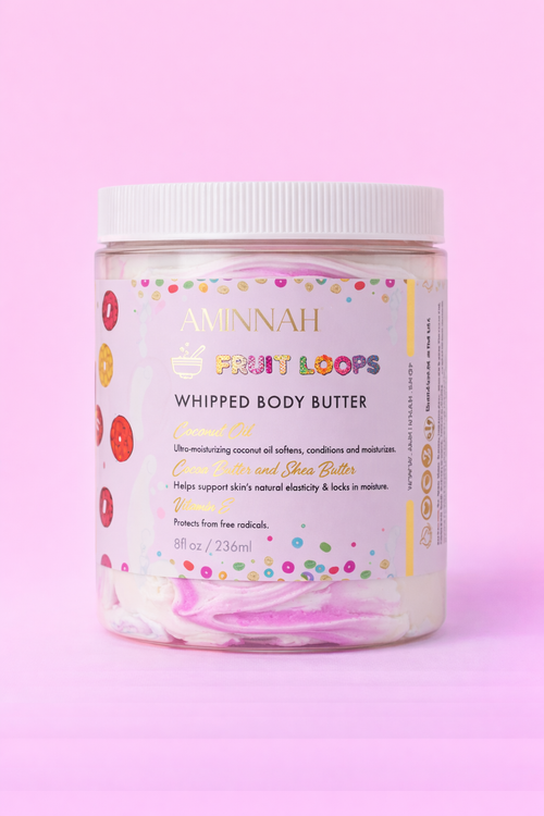 AMINNAH Frut Loops Whipped Body Butter in an 8 oz jar with colorful whipped body butter on a soft pink background. Clean beauty, cruelty-free, vegan body butter made with natural ingredients including shea butter, coconut oil, cocoa butter, and sweet almond oil to deeply moisturize and nourish skin. Female-owned brand available at Tree of Life Grocers.