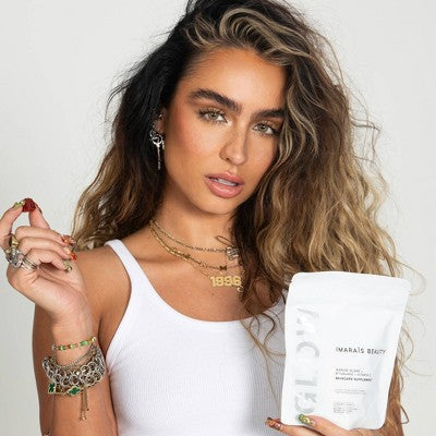 A woman holding a pouch of Imaraïs Beauty Glow Vegan & Sugar-Free Skincare Gummies, showcasing plant-based beauty supplements for radiant skin and healthy aging. Lifestyle product image featuring glowing skin, wellness gummies, and modern skincare nutrition.