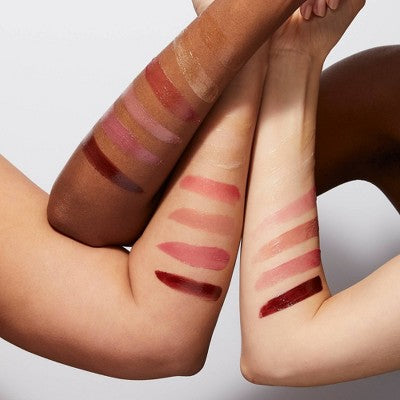 Three arms with swatches of lipstick on a neutral background.