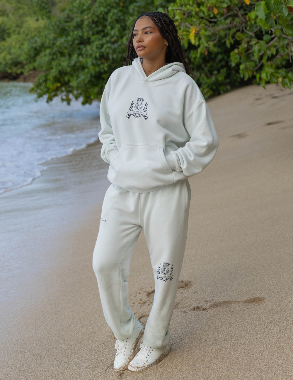 Person wearing a light gray hoodie and pants on a beach