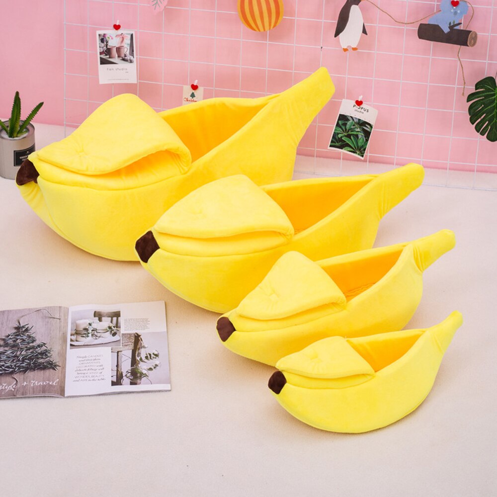 Soft plush banana-shaped pet bed with a cozy hooded design, available in multiple sizes for cats, kittens, puppies, and small dogs. Warm, comfortable, washable indoor pet bed that provides a secure cave-like sleeping space for restful naps and everyday comfort.