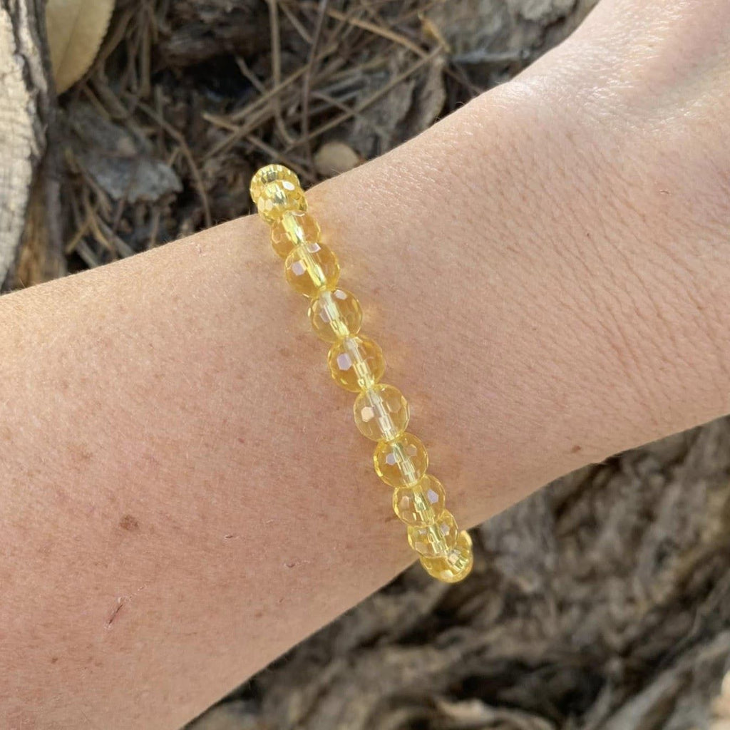 Yellow beaded bracelet on a wrist with a natural background. Citrine Bracelet 6 mm Faceted Round Beads – Abundance and Cheer