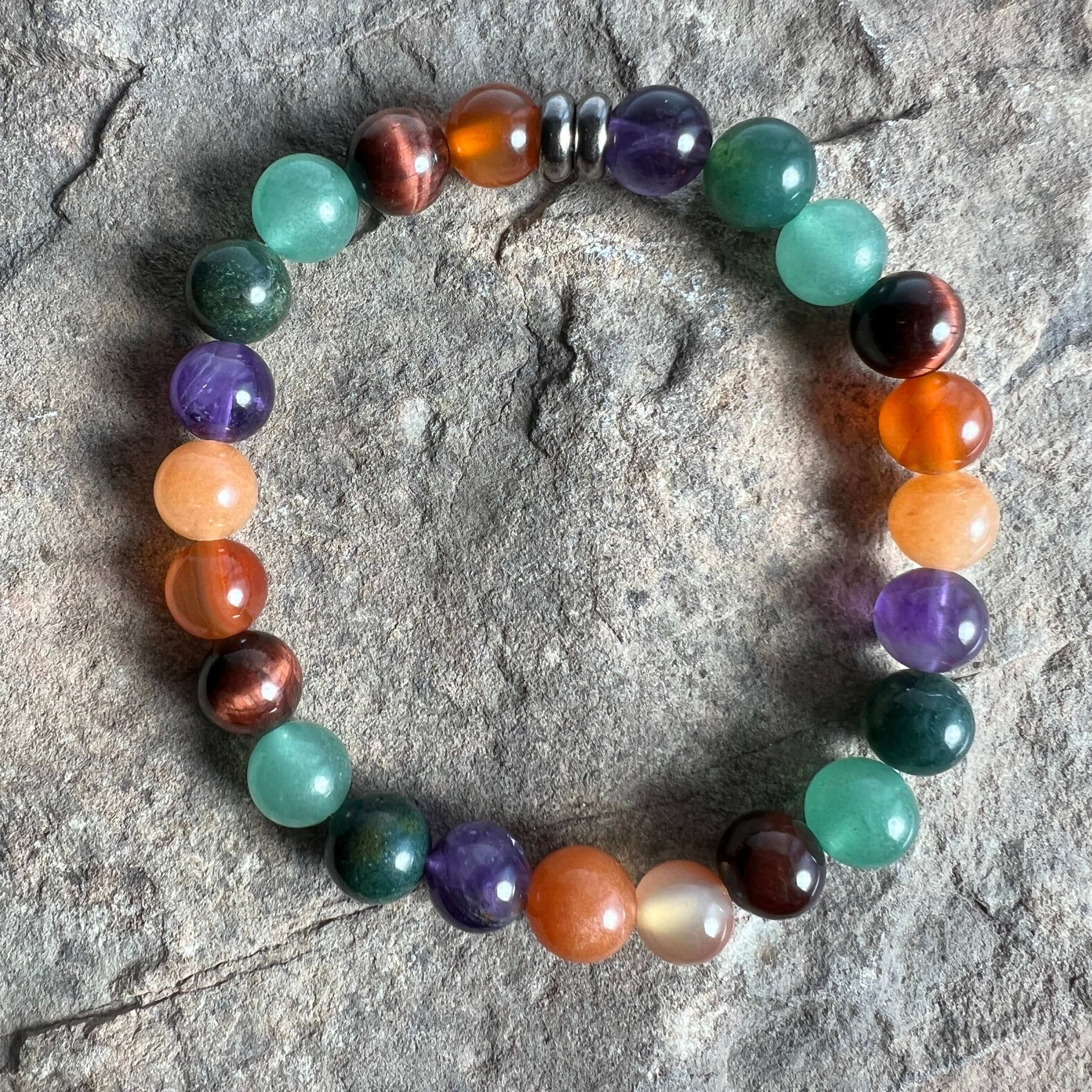 Multicolored beaded bracelet on a textured stone surface. Abundance & Motivation Vibes Bracelet