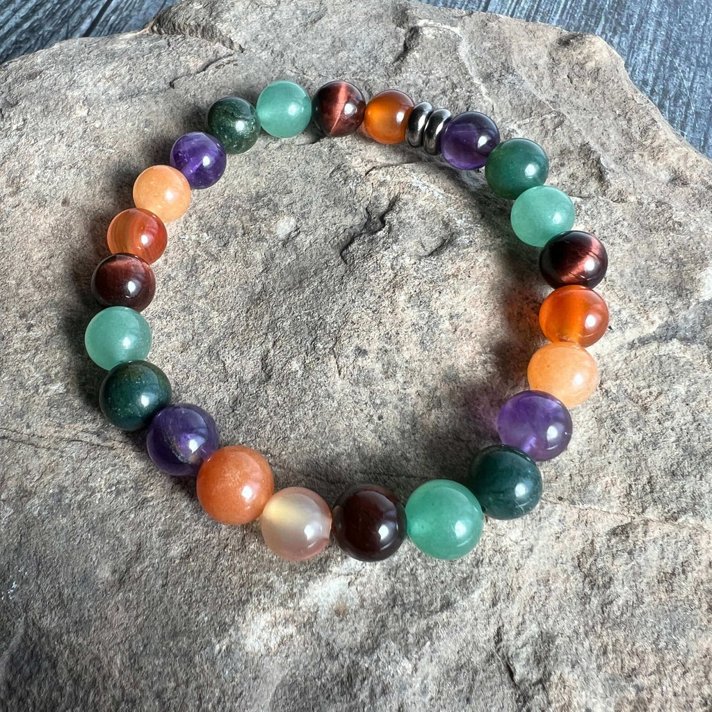 Multicolored beaded bracelet on a stone surface. Abundance & Motivation Vibes Bracelet