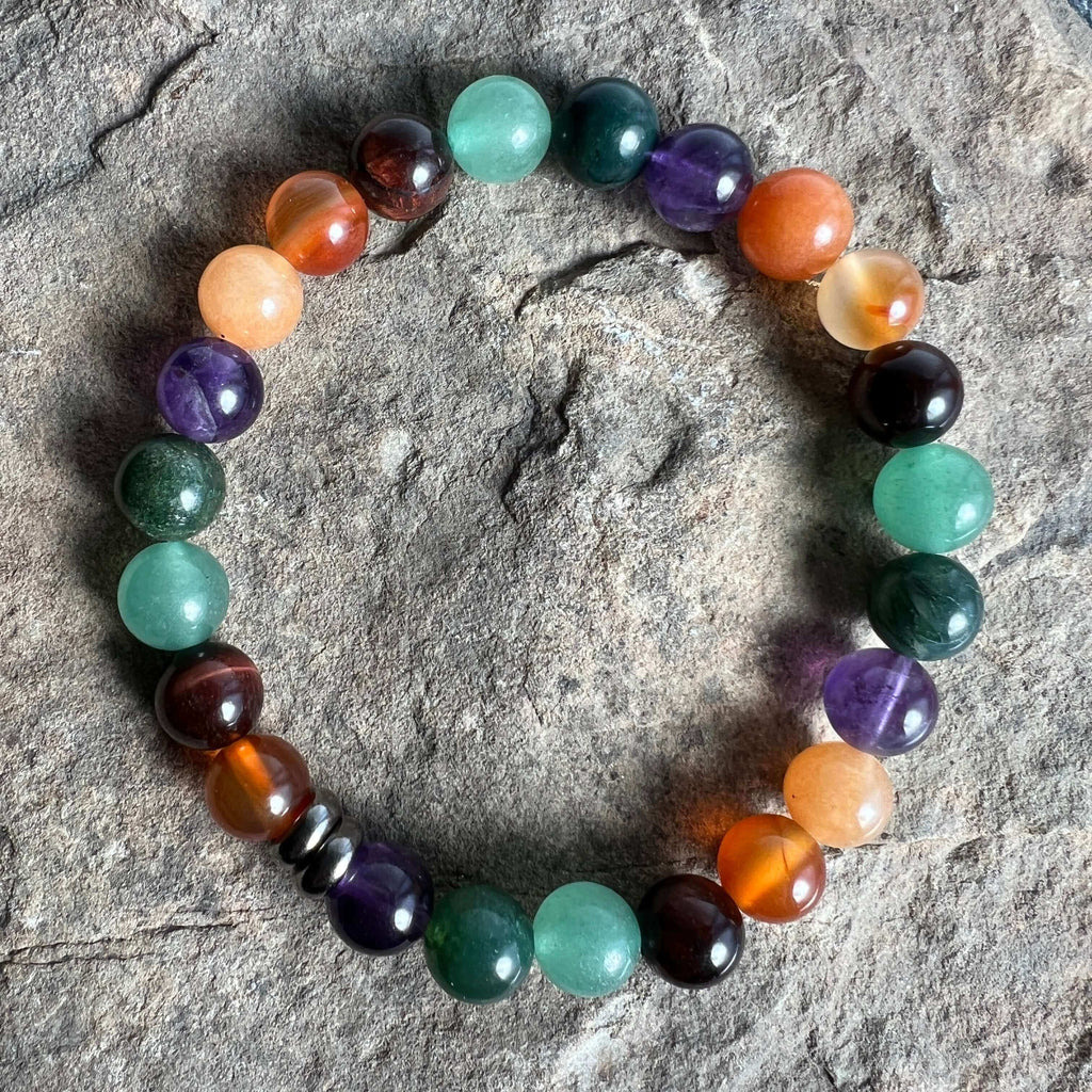 Multicolored beaded bracelet on a textured stone surface. Abundance & Motivation Vibes Bracelet