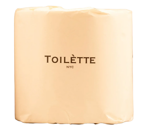 A cream-colored paper towel holder canister with the brand name 'TOILÈTE NYC' printed in dark brown on the front, set against a neutral beige background.