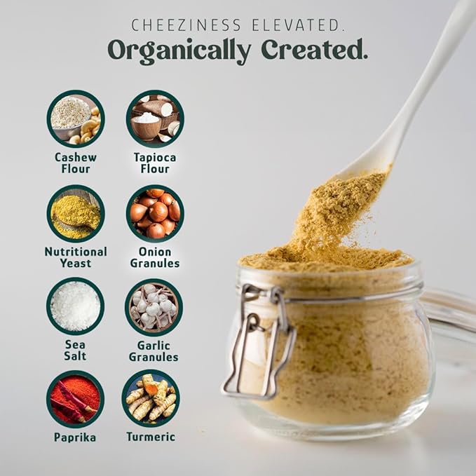 Glass jar of vegan instant cheese mix with a spoonful of seasoning powder, surrounded by ingredient icons including cashew flour, tapioca flour, nutritional yeast, onion granules, sea salt, garlic granules, paprika, and turmeric on a light background. Veggie chip dip