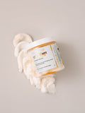 Toasted Marshmallow Sugar Scrub by AMINNAH with 24K gold dust on a clean white background, clean beauty exfoliating body scrub made with natural ingredients, vegan, cruelty-free, paraben-free, gluten-free skincare, female-owned brand, recyclable packaging, luxurious self-care gift, moisturizing body polish for soft glowing skin.