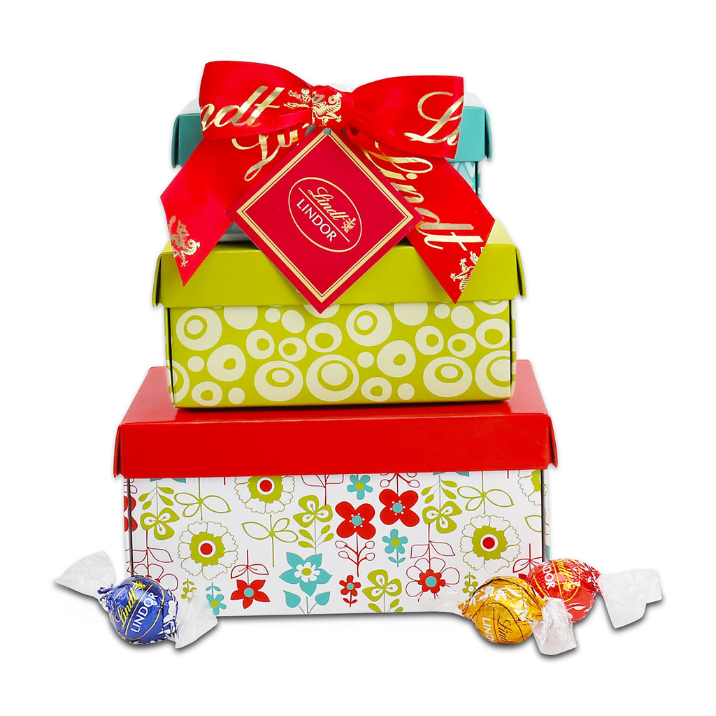 Colorful gift box with a red ribbon and Lindt logo, surrounded by Lindt chocolates on a white background.
