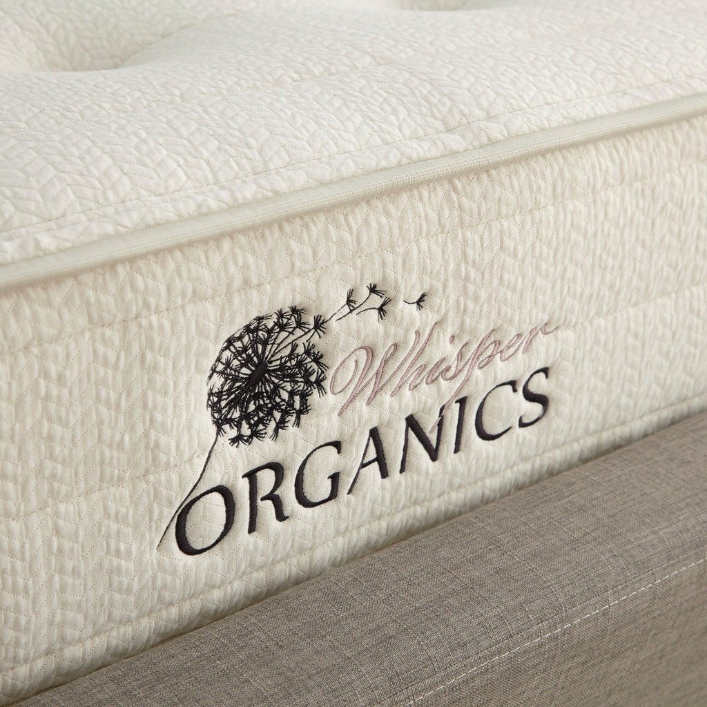 Close-up of a mattress with 'Whisper Organics' branding. Mattress on a bed in a bedroom with 'Whitney Organics' branding. 100% GOTS & GOLS-Certified organic cotton, wool and latex, 10" profile: 2" organic Dunlop latex + 7-zone pocketed coils, Medium feel for that “just right” balance of comfort + support, Breathable organic wool & cotton cover for airflow and temperature regulation, Lumbar support with zoned coil design, Suitable for an adjustable base & Made with sustainable, renewable materials, usa