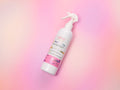AMINNAH Midnite Moon Daze Room Spray bottle displayed on a soft pink and lavender gradient background. Clean beauty, cruelty-free, vegan room spray crafted with naturally derived ingredients including steamed distilled water, coconut oil, and fragrance oil to refresh rooms, linens, and fabrics. Female-owned brand available at Tree of Life Grocers.