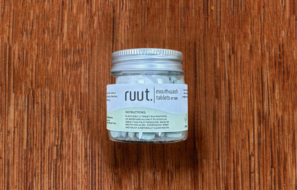 Jar of Ruut mouthwash tablets on a wooden surface, natural oral care, eco-friendly toothpaste alternative, dissolvable mouthwash tablets, sustainable dental care, plastic-free mouthwash, Ruut oral hygiene tablets, mint mouthwash tablets, zero-waste oral care, travel-friendly mouthwash, natural mouthwash tablets, refreshing oral care, bathroom wellness essential, Tree of Life Grocers.