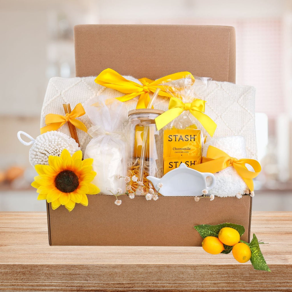 Gift basket with yellow ribbons, sunflower, and tea package on a wooden surface.