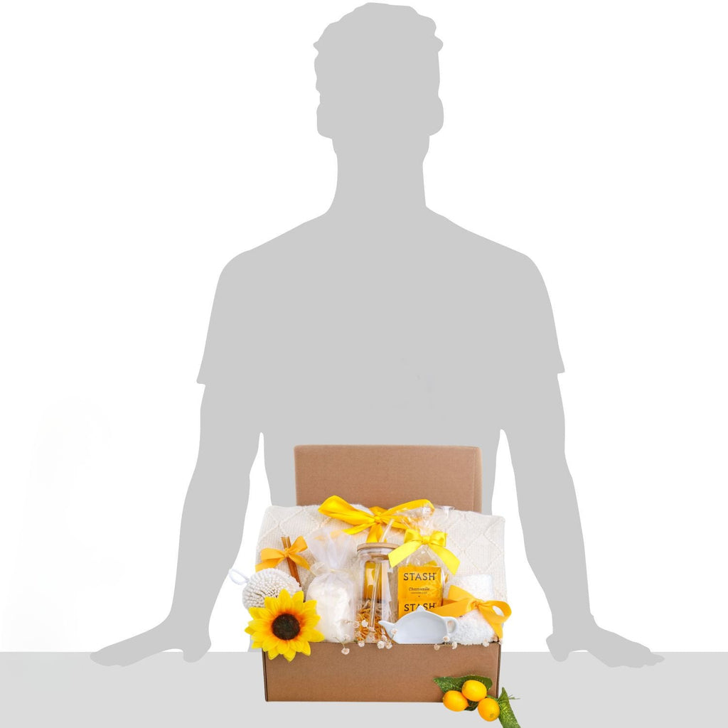 Gift box with sunflowers and a bottle of perfume on a white background