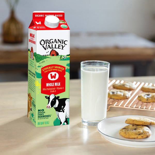 Organic Valley® USDA Certified Organic Whole Milk carton beside a full glass of fresh milk and homemade chocolate chip cookies on a kitchen table, highlighting rich, creamy, pasture-raised organic dairy in a 1-quart carton.