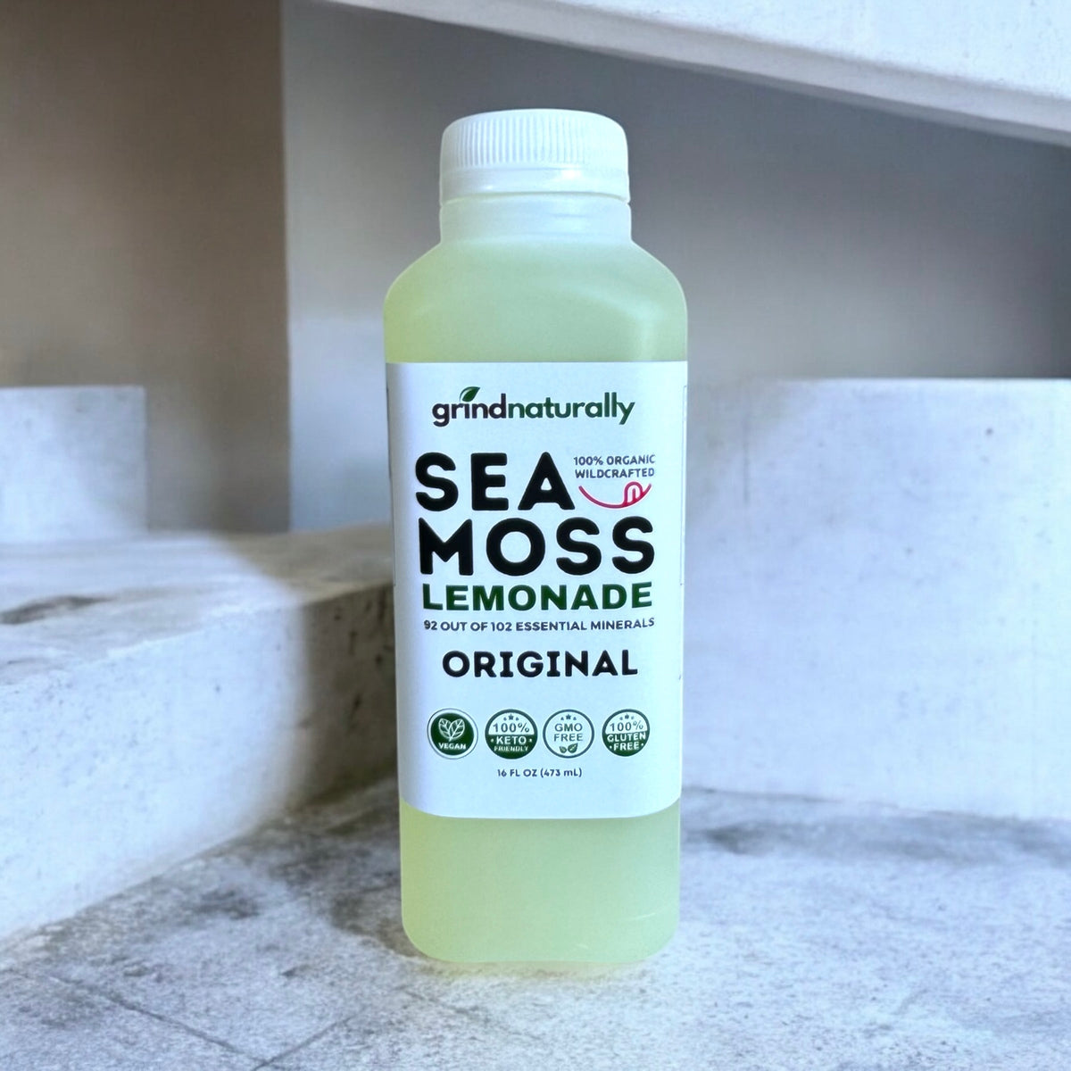 Bottle of Sea Moss Lemonade on a marble surface with a neutral background #1 Flavored Sea Moss Lemonade (16oz)