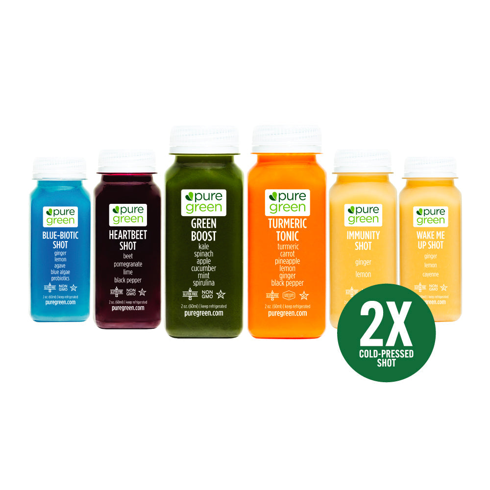 Pure Green cold-pressed juice shot variety pack featuring Blue Biotic, Heartbeet Shot, Green Boost, Turmeric Tonic, Immunity Shot, and Wake Me Up Shot bottles on a white background with 2X cold-pressed shot badge. Pure Green's Shot Variety Pack is twelve 2oz HPP cold-pressed shots — two each of all six Pure Green shot formulas: Immunity, Heartbeet, Turmeric Tonic, Green Boost, Wake Me Up, and Blue Biotic.