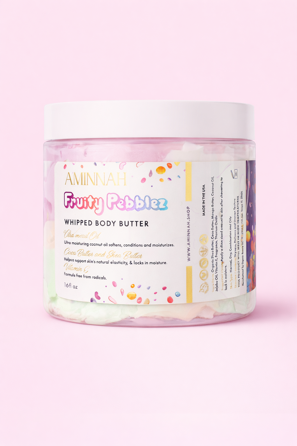 AMINNAH FRUITY PEBBLEZ Whipped Body Butter 16 OZ in a clear jar with colorful whipped body butter on a soft pink background. Rich moisturizing body butter made with shea butter, mango butter, vitamin E, and essential oils to help soften and nourish skin. Clean Beauty, cruelty-free, vegan, made with natural ingredients, female-owned brand, made in the USA, available at Tree of Life Grocers.