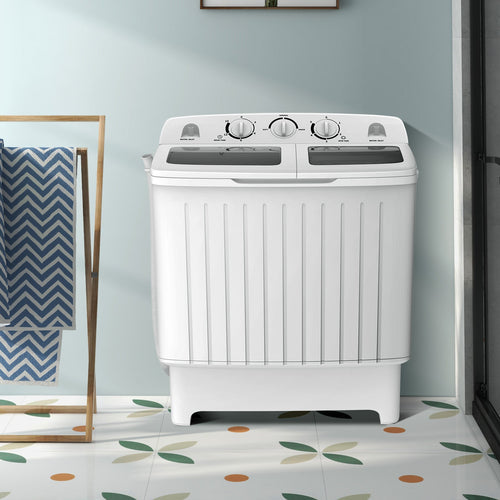 White washing machine in a room with a light blue wall and patterned floor.