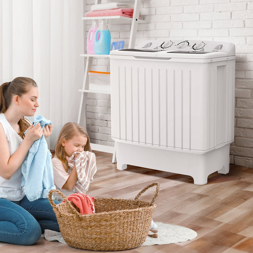 Woman and child sorting laundry in a room with a white washing machine.