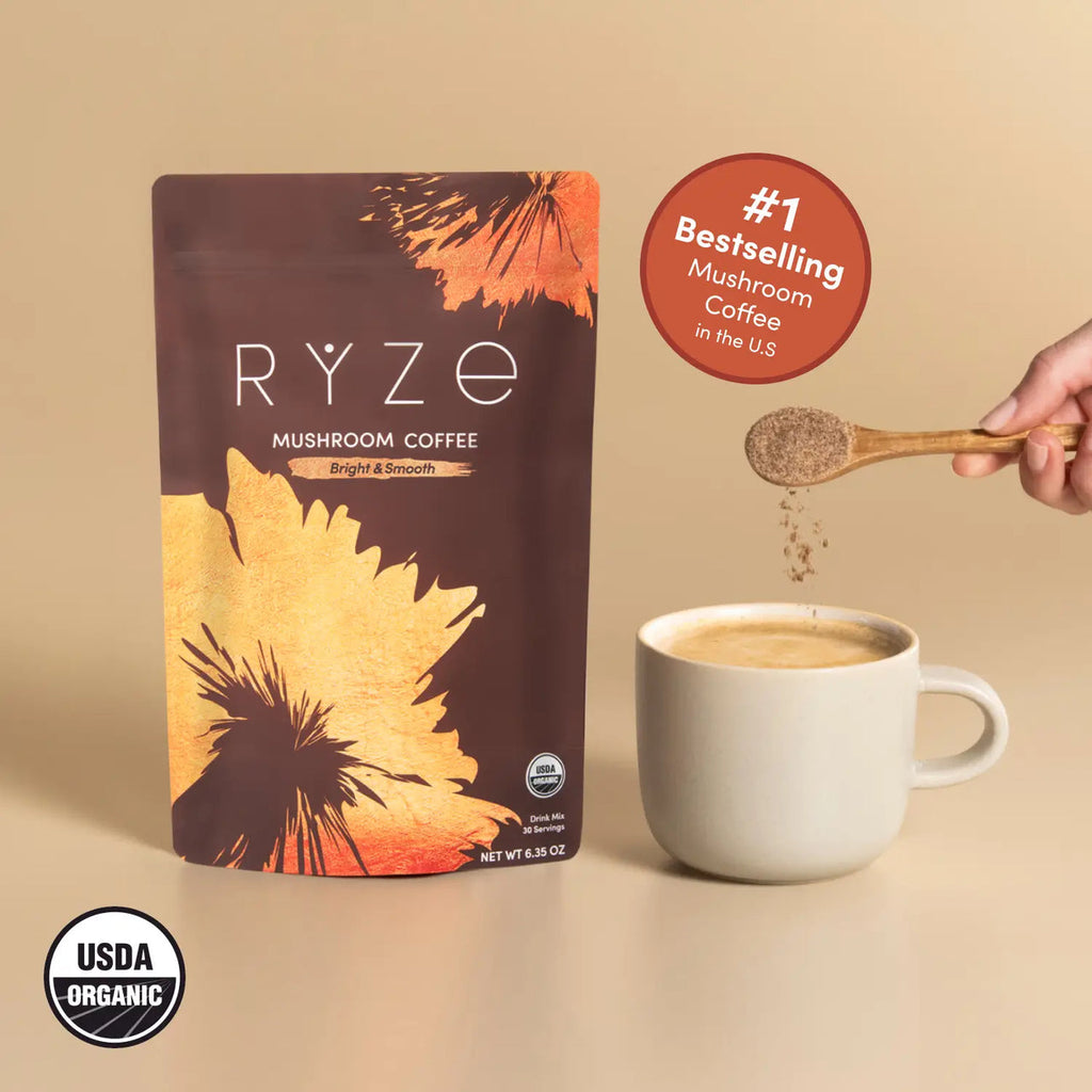 RYZE Superfoods Mushroom Coffee with organic Arabica coffee, six adaptogenic mushrooms, and MCT oil beside a freshly brewed mug for clean energy, focus, and wellness. USDA Organic Bestselling Mushroom Coffee in the USA.