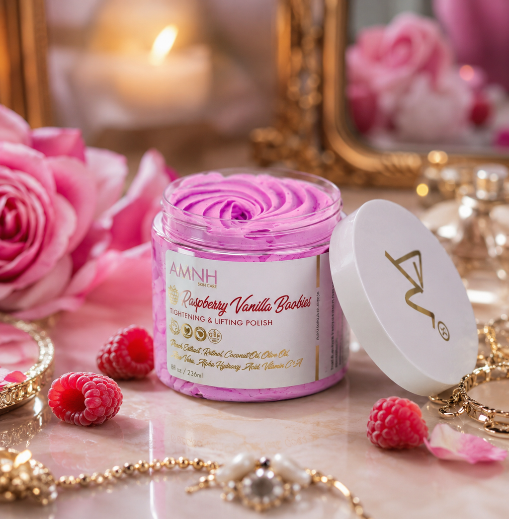 Raspberry Vanilla Boobies Tightening & Lifting Sugar Scrub in a reusable jar with whipped raspberry-pink polish on a marble vanity surrounded by fresh raspberries, pink roses, and gold jewelry. Luxury body exfoliating polish made with natural ingredients to gently exfoliate, smooth, soften, and nourish skin. Clean beauty, vegan, cruelty-free, paraben-free, gluten-free formula with recyclable packaging from a female-owned brand for radiant, silky-soft skin.
