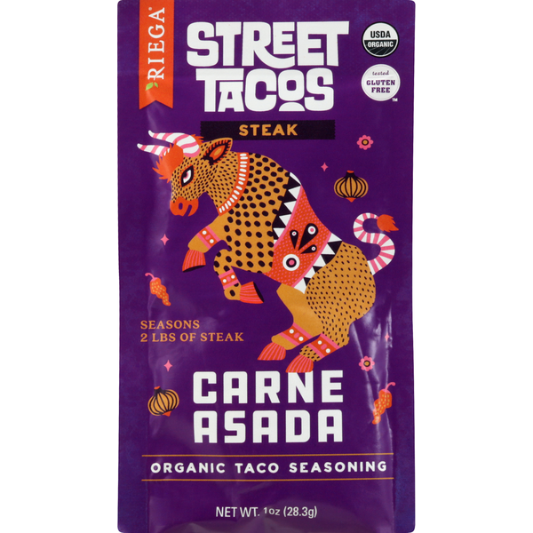 Organic Riega Street Tacos Carne Asada Steak taco seasoning packet with vibrant purple packaging featuring a colorful folkloric dragon illustration. USDA Organic and Certified Gluten Free labels displayed on the front, designed for seasoning up to 2 pounds of steak. 1 oz (28.3 g) seasoning packet.