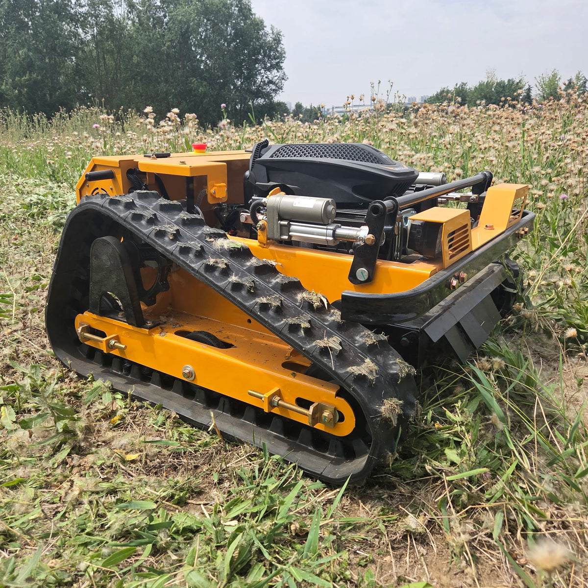 Yellow remote-controlled tracked lawn mower with all-terrain crawler tracks, automatic climbing capability and heavy-duty cutting system for gardens, orchards, farms, fields and efficient weed clearing.